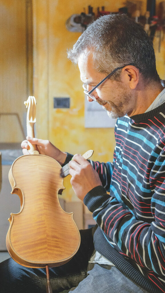 Marco dipinge un violino destinato al noleggio